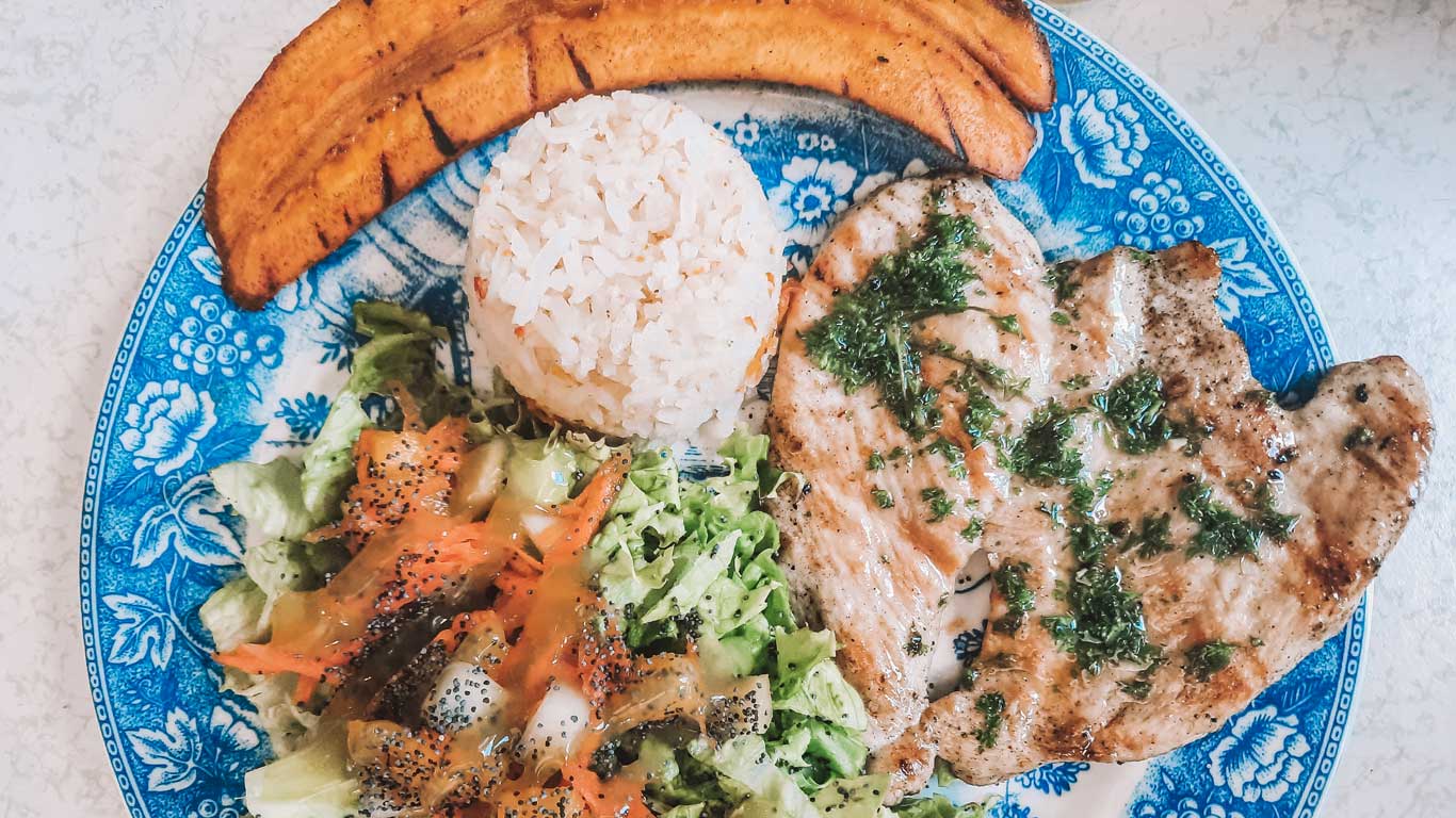 Almuerzo con pollo, arroz y ensalada en el restaurante La Tía o Ladraba en Laureles.