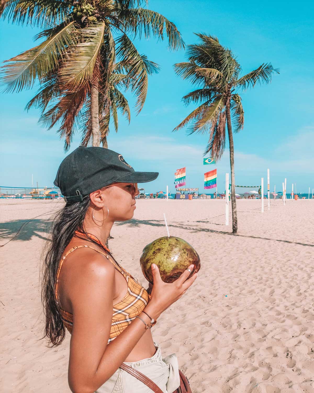 Chica tomando agua de coco en la Playa de Copacabana, una de las mejores zonas para quedarse en Río de Janeiro.