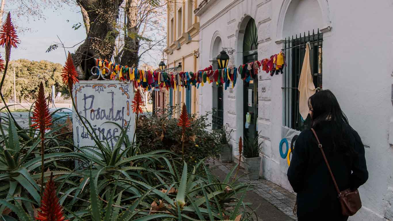 Mujer con un abrigo oscuro caminando por las calles del Casco Histórico, una de las mejores cosas que hacer en Colonia del Sacramento.