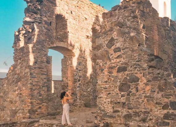 Una mujer admirando las ruinas del Convento de San Francisco, a los pies del Faro de Colonia del Sacramento.