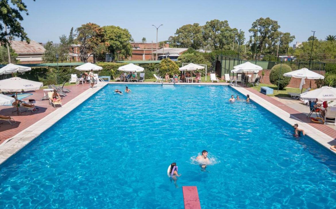 La piscina del El Mirador Hotel & Spa en Colonia del Sacramento está muy animada, con muchas personas disfrutando de un día soleado.
