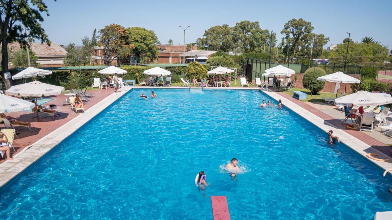 La piscina del El Mirador Hotel & Spa en Colonia del Sacramento está muy animada, con muchas personas disfrutando de un día soleado.
