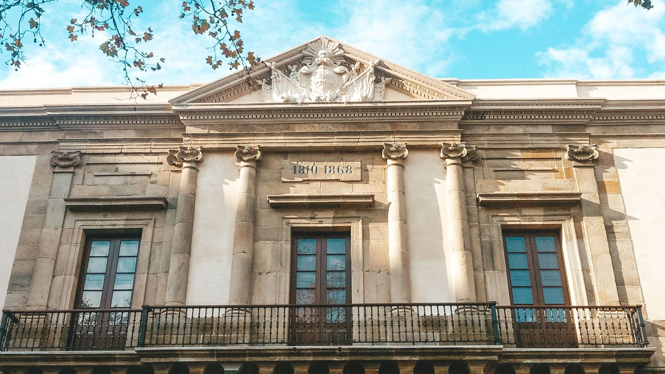 Fachada del Cabildo de Montevideo, destacando sus columnas clásicas y detalles arquitectónicos ornamentados. La inscripción "1808" se puede ver en la parte superior, reflejando la importancia histórica del edificio.