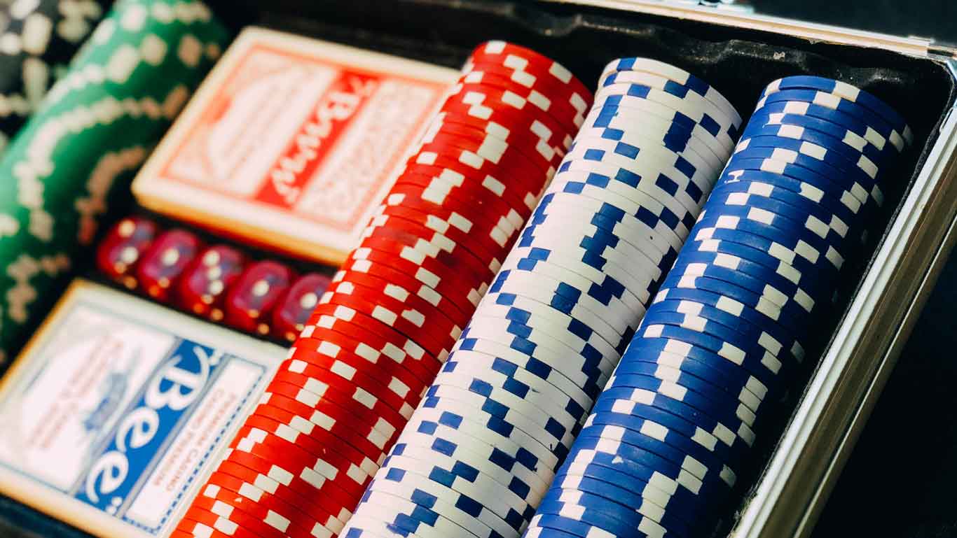 La imagen muestra un conjunto de fichas de póker y dos barajas de cartas dentro de un estuche, lo que sugiere una actividad de juego, típica de los casinos. Esta fotografía puede estar relacionada con lo que hacer en Punta del Este, donde uno de los pasatiempos populares es visitar sus famosos casinos. 