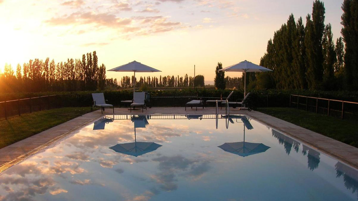 Imagen de la piscina de la Posada Salentein con vistas a los viñedos al atardecer.