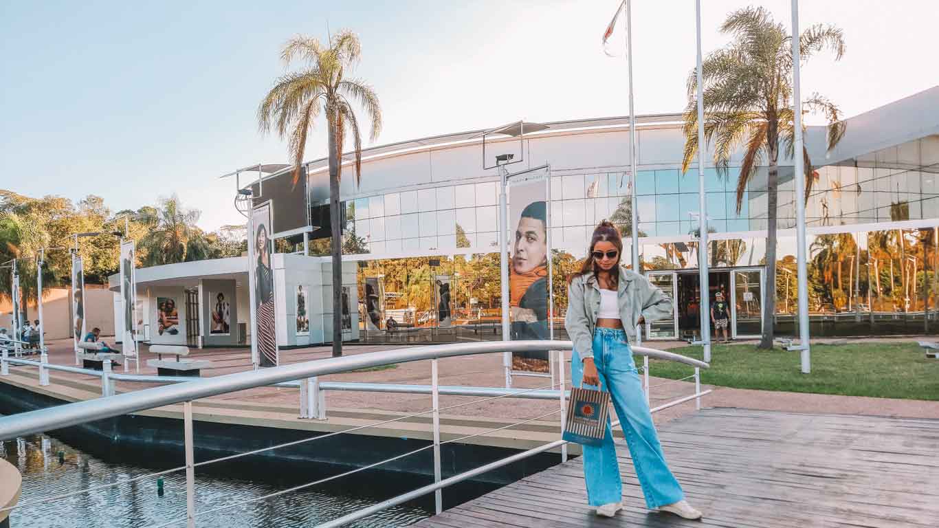 Mujer posando frente al Duty Free Puerto Iguazú, con bolsas de compras.