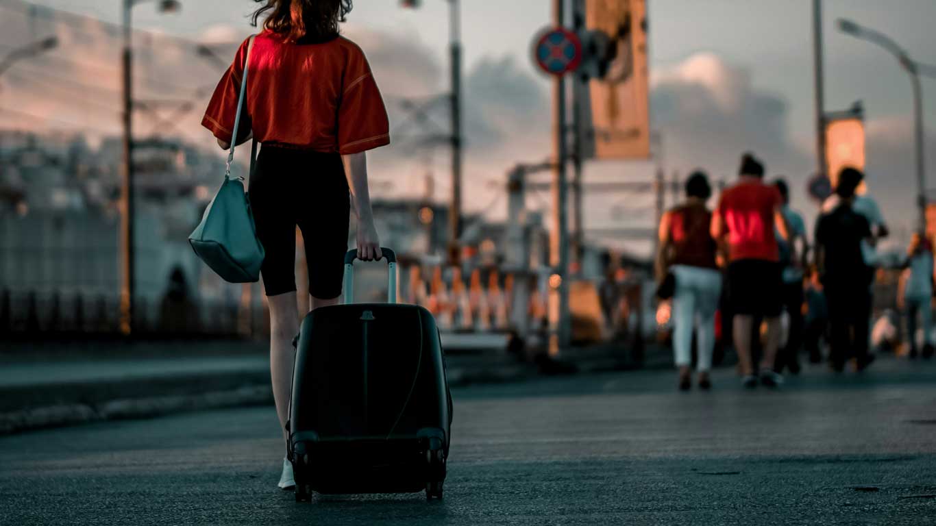 Una mujer tirando de una maleta para Europa en primavera.