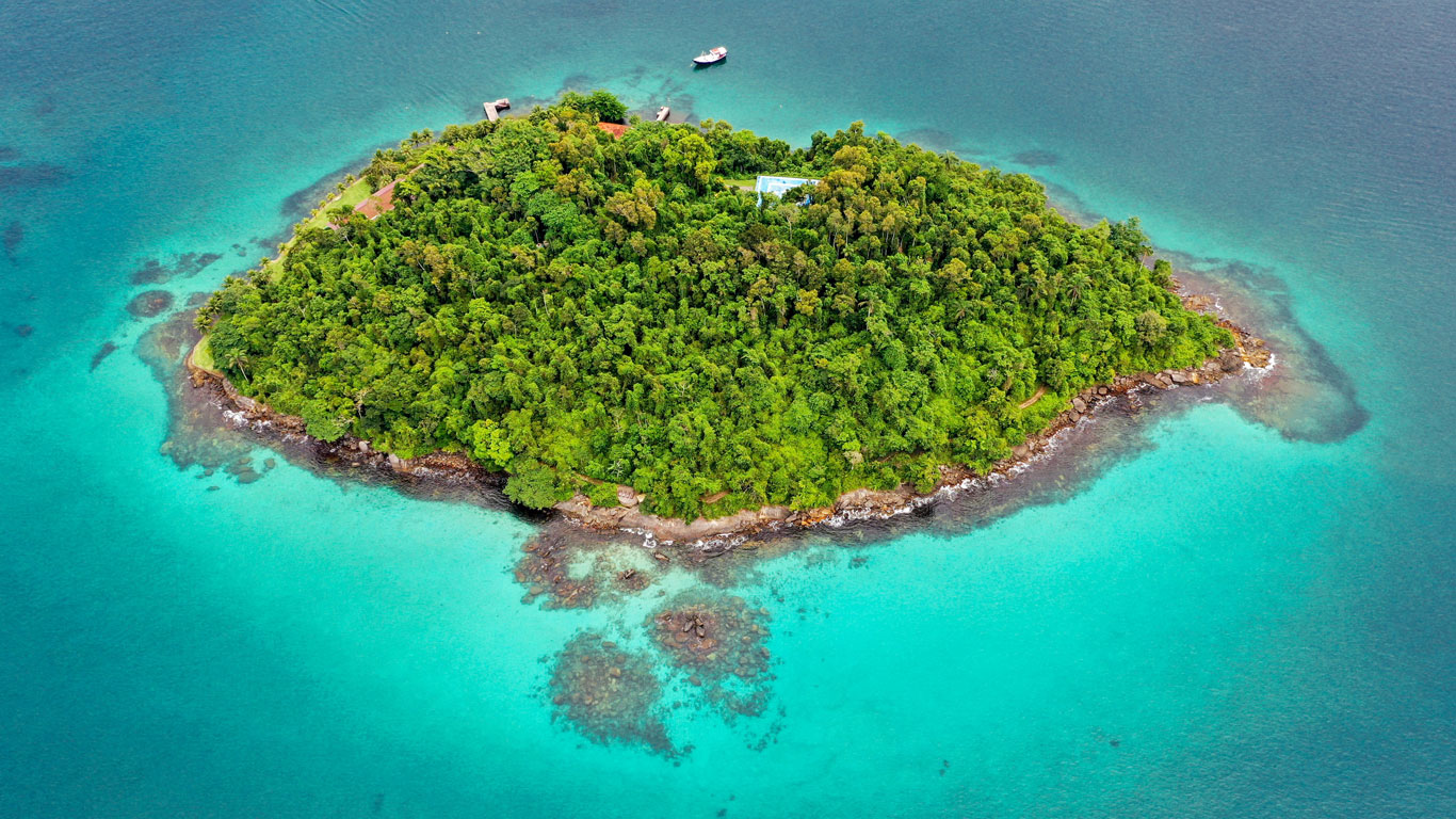 Vista aérea de una pequeña isla cubierta por la mata atlántica, perdida en el océano de aguas turquesas en Angra dos Reis, uno de los mejores lugares para conocer cerca de Rio de Janeiro.