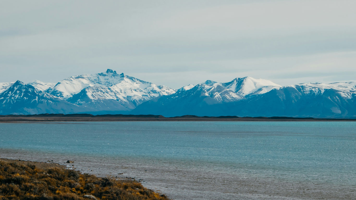 Vista del lago de El Calafate en Argentina, con aguas azules y las montañas nevadas al fondo.