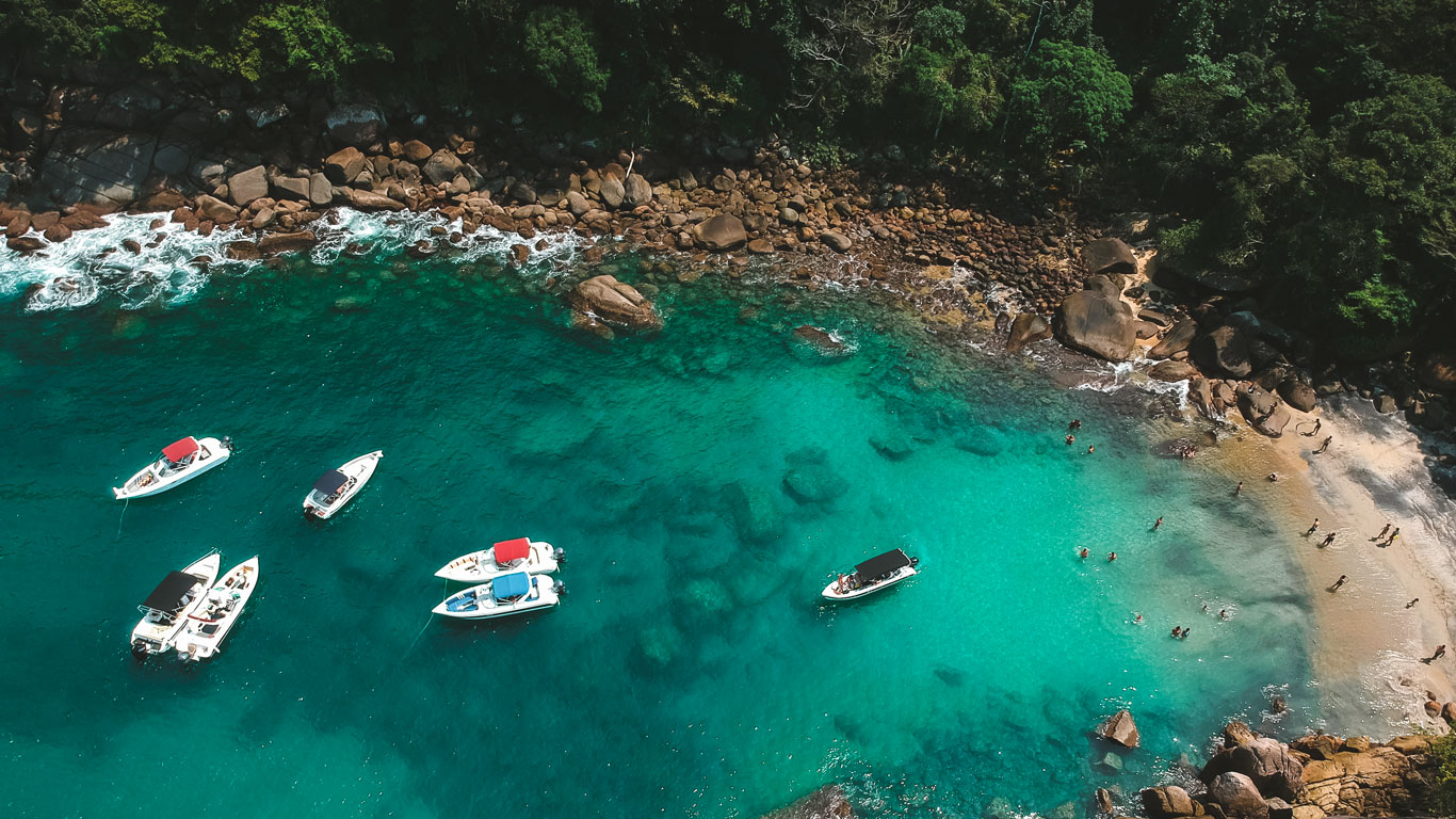 Vista aérea de la Playa do Cachadaço en Ilha Grande, con un barco detenido sobre las aguas cristalinas.