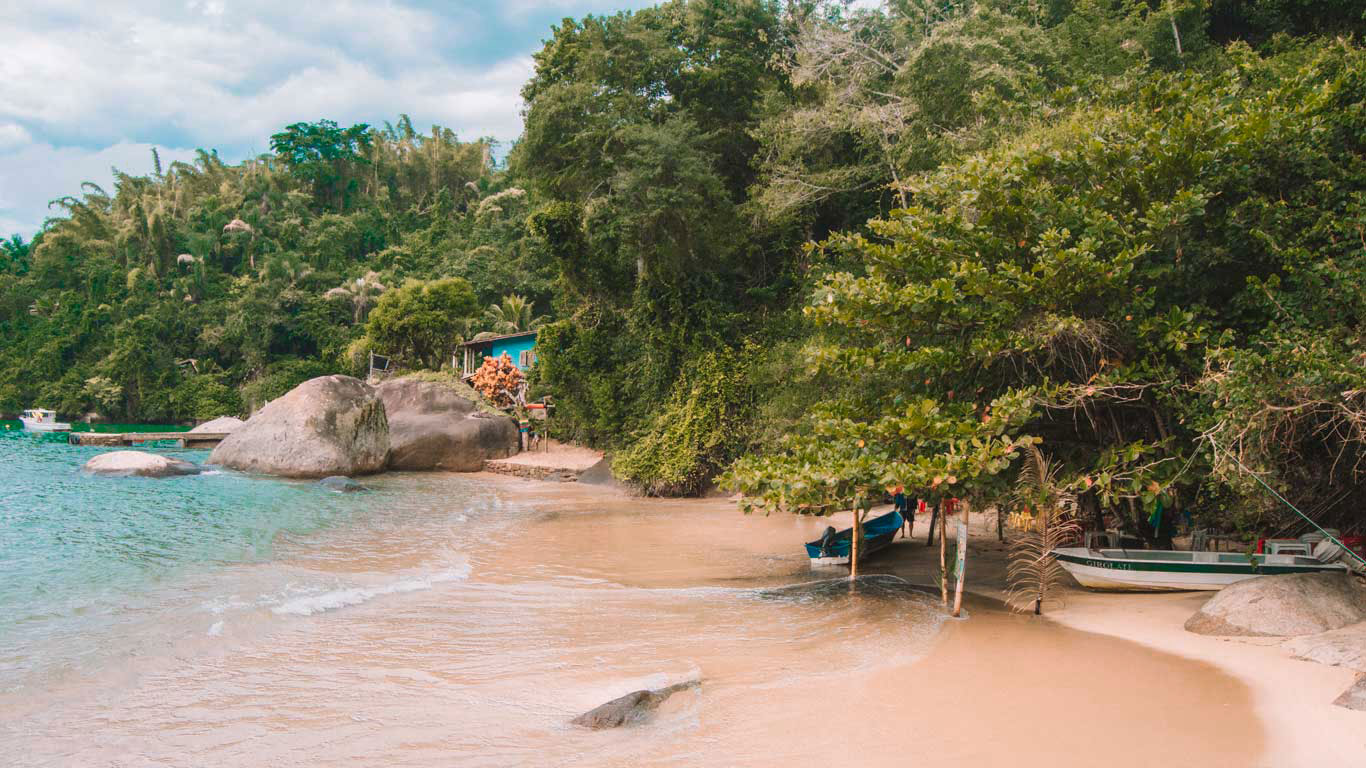 Playa de Paraty en Río de Janeiro, con el mar azul fusionándose con el verde de la naturaleza.