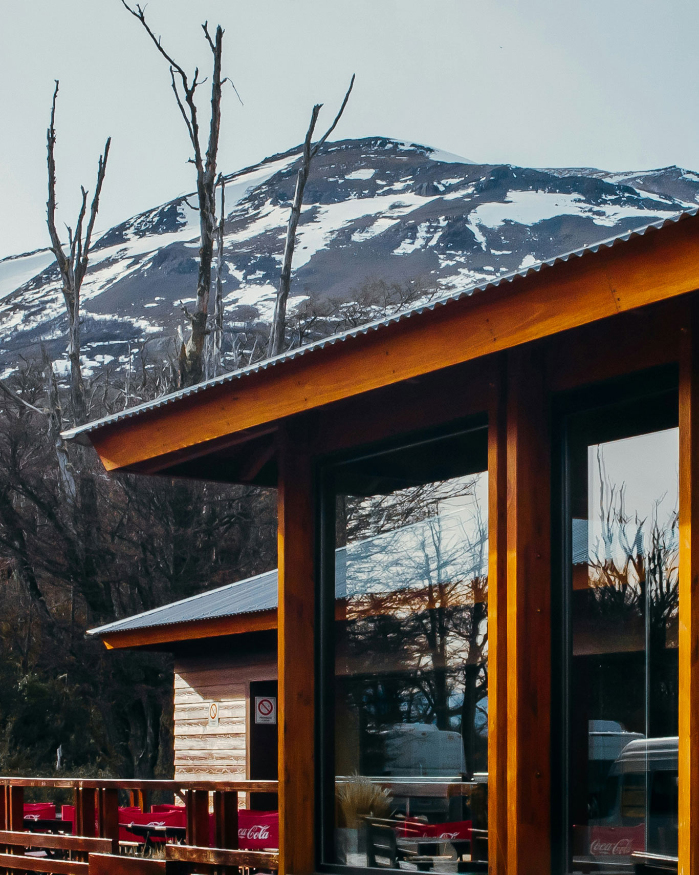 Casa en el centro de El Calafate, con arquitectura de madera y vidrio, y una montaña nevada al fondo.