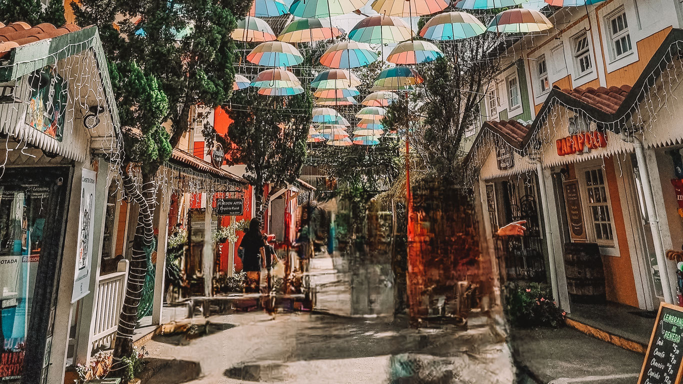 Centro de Penedo, con tienditas coloridas y una calle cubierta de paraguas de colores.