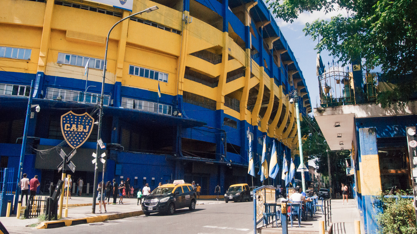 boca-juniors Fachada del estadio La Bombonera, del Boca Juniors, con aficionados y banderas en los colores azul y amarillo.