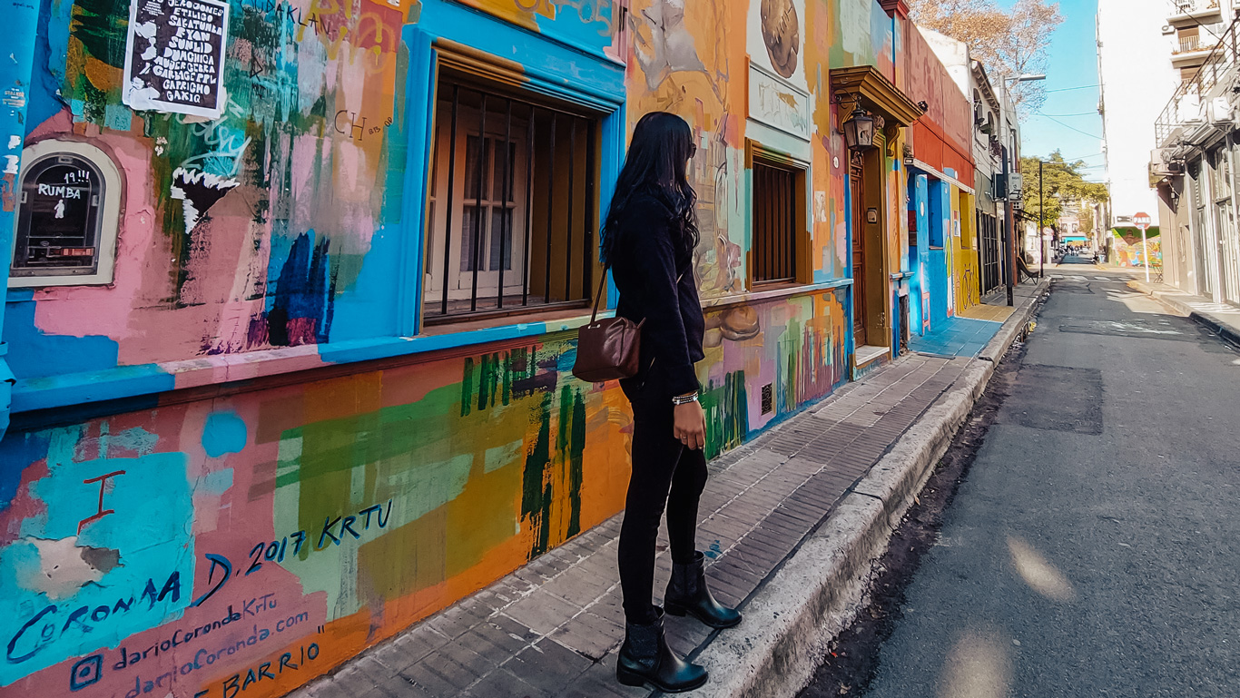 pallermo-calle-russel Una mujer vestida con ropa de abrigo negra posa de forma relajada para una foto en la Calle Russel, una calle llena de arte urbano en Palermo.