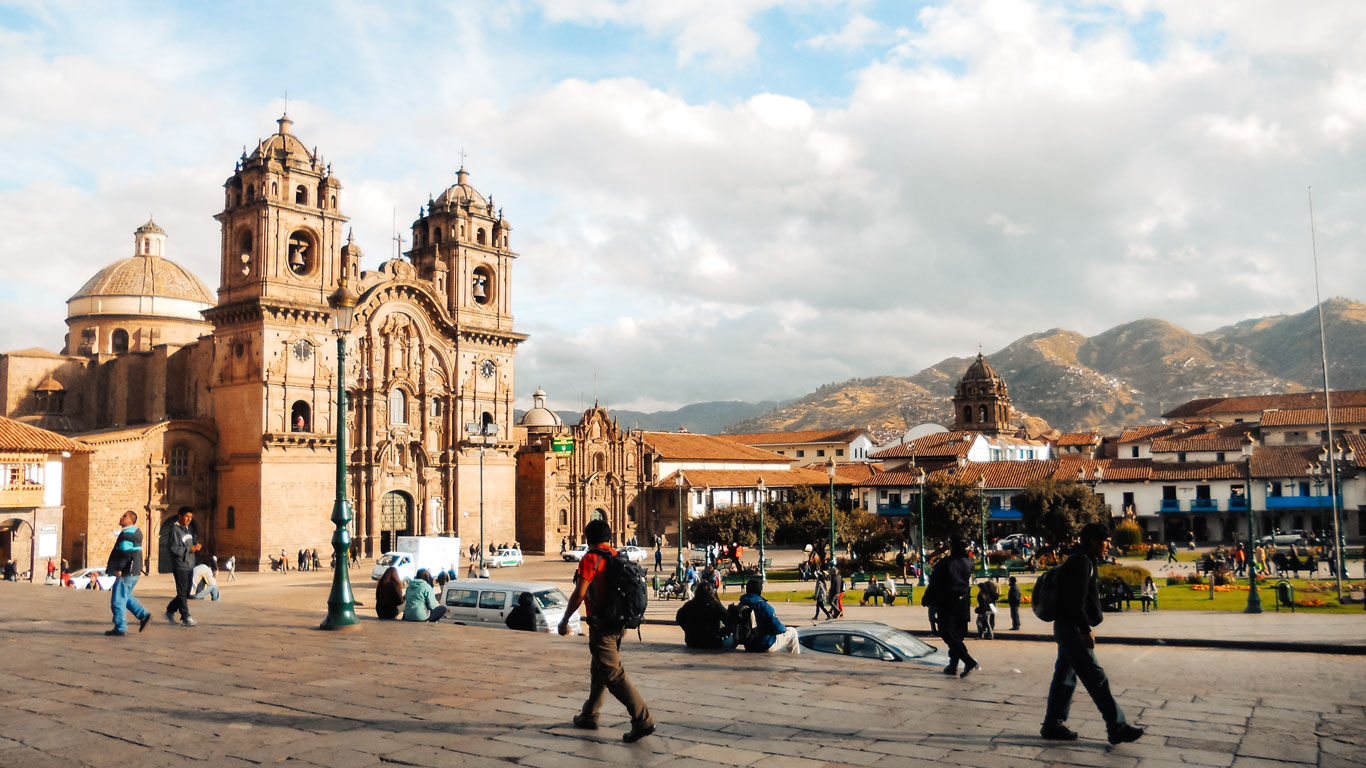Plaza central de Cusco con la imponente Catedral y vistas a las montañas al fondo.