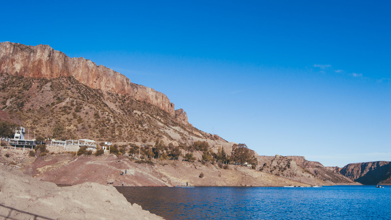 Vista panorámica del Cañón del Atuel en San Rafael, rodeado de montañas áridas y rocosas bajo un cielo azul claro.